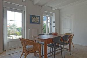 comedor con mesa de madera y sillas en Le Gîte de Ker Ehden classé 3 étoiles en Ploubazlanec