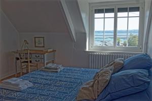 a bedroom with a bed and a desk and a window at Le Gîte de Ker Ehden classé 3 étoiles in Ploubazlanec