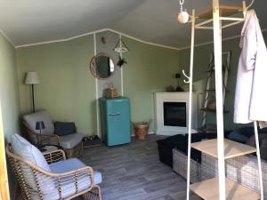 ein Wohnzimmer mit einem blauen Kühlschrank und einem Sofa in der Unterkunft Ferienwohnung mit Blick auf den Kickelhahn in Ilmenau