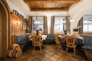 un restaurant avec deux tables, des chaises et des fenêtres dans l'établissement Das Mondschein, à Obereggen