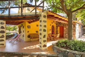 a yellow house with a patio with a table at Finca Los Dioses I in Mogán