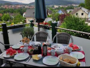 een tafel met borden eten op een balkon bij Ferienwohnung mit Blick auf den Kickelhahn in Ilmenau
