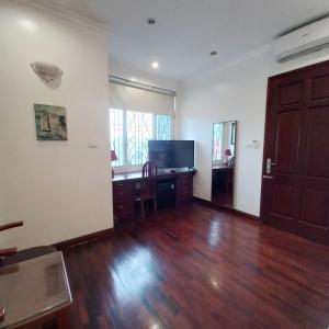 an empty living room with a desk and a television at Huong Giang Guest House in Hanoi
