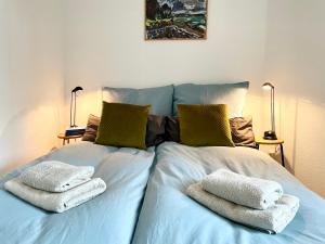 1 cama con 2 toallas y 2 lámparas en Modern Design 3-Bedroom Appartement, Central, Beliebt, en Halle an der Saale
