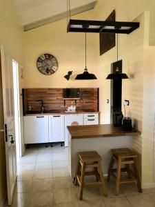 a kitchen with a counter and a sink and a clock at Joli studio Coeur de Canne piscine et plage en Martinique in Les Trois-Îlets