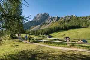 a group of people walking on a path in the mountains at Dolomites Smart Holidays in Valdaora