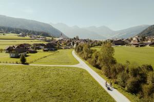 eine kurvenreiche Straße durch ein Dorf in den Bergen in der Unterkunft Dolomites Smart Holidays in Olang