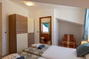 a bedroom with a bed and a chair and a mirror at Villa Fontana in Trogir