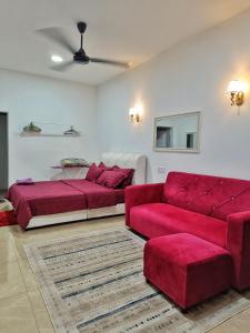 a living room with two beds and a red couch at PD ROOM STAY in Port Dickson