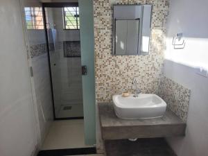 a bathroom with a sink and a mirror at Rancho Morro do Cristo - Ribeirão Claro PR in Ribeirão Claro