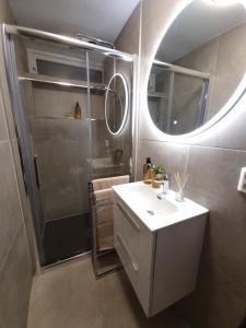 y baño con lavabo y ducha con espejo. en Studio Apartament NORDBAKKEN, Perfect for World Cup Trondheim 2025 ONLY 1700m to SKI SENTER GRANÅSEN, en Trondheim
