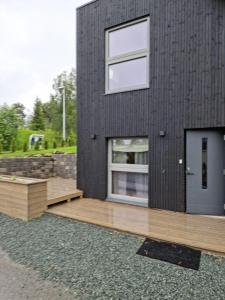 Casa negra con terraza de madera y ventana en Studio Apartament NORDBAKKEN, Perfect for World Cup Trondheim 2025 ONLY 1700m to SKI SENTER GRANÅSEN en Trondheim