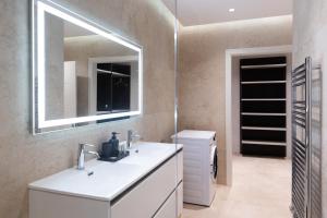 y baño con lavabo blanco y espejo. en Florette Suite 1BR in Floriana, en Floriana