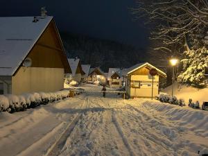 een met sneeuw bedekte straat met een schuur 's nachts bij IKS holiday in Karpacz