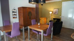 ein Esszimmer mit einem Holztisch und lila Stühlen in der Unterkunft The4Seasons in Loon