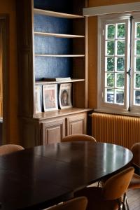 ein Esszimmer mit Tisch und Stühlen und einem Fenster in der Unterkunft Maison Maa, Maison principale, à 10 min de Saint-Valery-sur-Somme à pieds le long du canal in Boismont