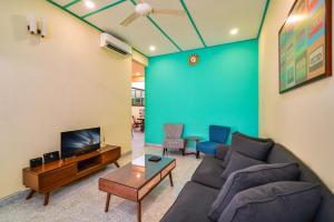 - un salon avec un canapé et une télévision dans l'établissement Dream & Wander Homestay, à Ipoh