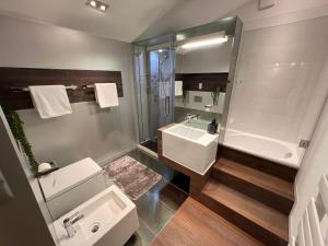 a bathroom with a sink and a tub and a toilet at Apartament ZETA - CITY 2 in Ustroń