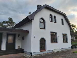 a white house with a black roof at Haus am Wald - Haus Nils und Haus Nele in Bark