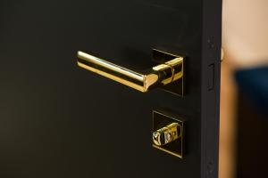 ein goldener Türknauf an einer schwarzen Tür in der Unterkunft Black Pearl Apartment starówka in Elblag