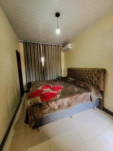 a bedroom with a bed with red flowers on it at Pousada Portal da Chapada in Rio de Contas