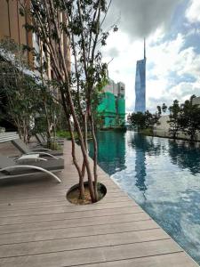 un albero seduto su una passerella accanto alla piscina di Lucentia Residence by EAS Maju property a Kuala Lumpur