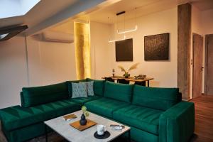 een woonkamer met een groene bank en een tafel bij The Skyline Suite in Florina