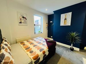a bedroom with a bed and a blue wall at City Hideout - Centrally Located Studio in Liverpool