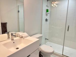 a bathroom with a sink and a toilet and a shower at City Lake 2 Storey Condo in Toronto