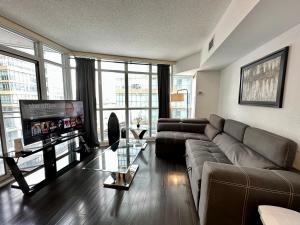 a living room with a couch and a flat screen tv at City Lake 2 Storey Condo in Toronto