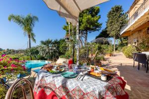 einen Tisch mit Essen darauf neben einem Pool in der Unterkunft B&B Villa San Marco in Agrigento