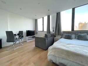 Un dormitorio con una cama, un escritorio y una silla. en Amazing Views of the City, en Mánchester