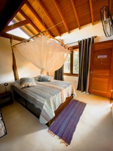 a bedroom with a bed with a mosquito net at CASA Ecológica Paraty in Paraty