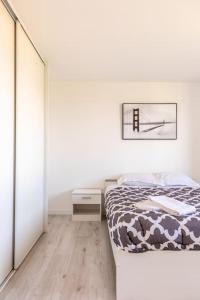 um quarto branco com uma cama e uma cómoda em Maison Piscine Zénith d'auvergne Clermont Sud em La Roche-Blanche