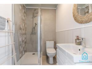 a bathroom with a toilet and a shower and a sink at Shiny Apartment in Gdańsk