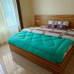 a bedroom with a large bed with a wooden frame at COLIBRI VILLA Bon Berger in Gisenyi