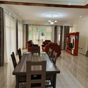 a living room with a wooden table and chairs at COLIBRI VILLA Bon Berger in Gisenyi