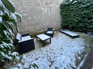Tres sillas y un banco en la nieve en Le Standing Metz Un Séjour à Part, en Metz