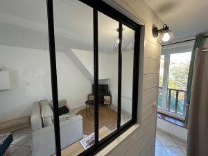 ein Wohnzimmer mit Glasfenstern und einem Sofa in der Unterkunft Quartier de l'Hôtel des Bains in Moirans