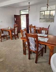 a dining room with wooden tables and chairs at Lala Inn Kikopey in Gilgil