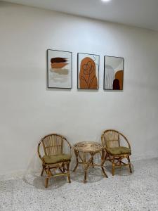 dos sillas y una mesa frente a una pared con fotos en Pure Essence Retreat Homestay - Taman Pelangi , Pelangi , Jalan Hijau Muda , Johor Bahru Town, en Johor Bahru