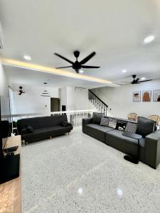 sala de estar con 2 sofás y ventilador de techo en Pure Essence Retreat Homestay - Taman Pelangi , Pelangi , Jalan Hijau Muda , Johor Bahru Town, en Johor Bahru