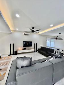 sala de estar con sofá y ventilador de techo en Pure Essence Retreat Homestay - Taman Pelangi , Pelangi , Jalan Hijau Muda , Johor Bahru Town, en Johor Bahru