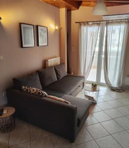 een woonkamer met een bank en een groot raam bij Vravrona Artemis Home & Transfer Airport in Artemida