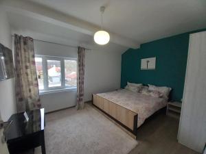 ein Schlafzimmer mit einem Bett und einer grünen Wand in der Unterkunft 4 Seasons Apartments in Bistriţa