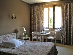 1 dormitorio con cama, mesa y ventana en Hotel Million, en Albertville