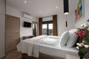 une chambre avec un lit avec des draps blancs et une fenêtre dans l'établissement Casa Oliveto by Briskva, à Labin 35 autres photos