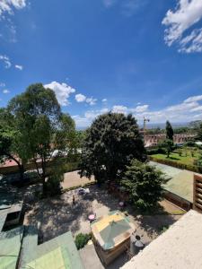 einen Blick über einen Park mit Pool und Bäumen in der Unterkunft SRS (Swadakta Royal Suites) in Nakuru