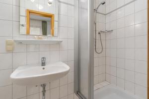 y baño blanco con lavabo y ducha. en BmB Vollersode Monteurzimmer / Pension, en Vollersode