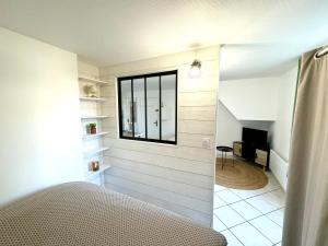 a bedroom with a bed and a window at La Pause Moirannaise in Moirans